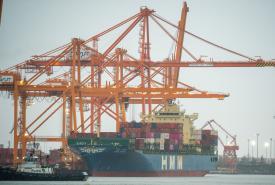 HMM Shipping Line vessel Hyundai Supreme is seen under ship-to-shore cranes at Washington United Terminals at the Port of Tacoma in December 2025. 